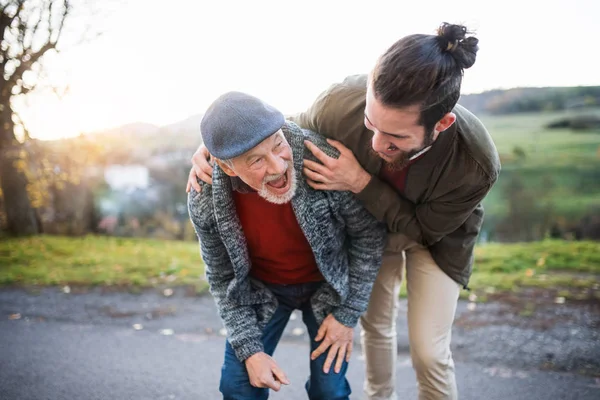 Ung man och hans Senior far på en promenad i naturen, skrattar. — Stockfoto