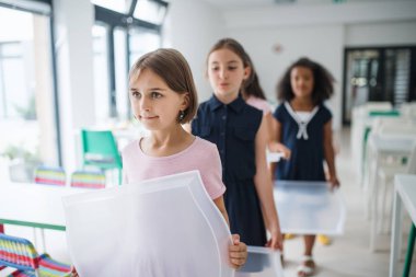 Kantinde plastik tepsiler ile neşeli küçük okul çocuklar grubu, yürüyüş.