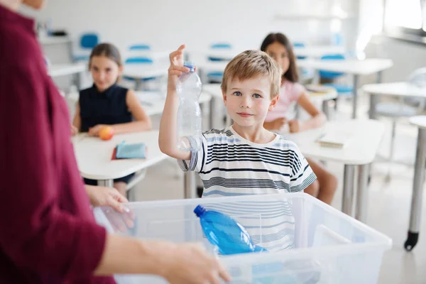 Um professor com crianças pequenas em sala de aula aprendendo sobre separação de resíduos . — Fotografia de Stock