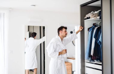 Sabah yatak odasında genç bir adam ne giyecek lerine karar veriyor..