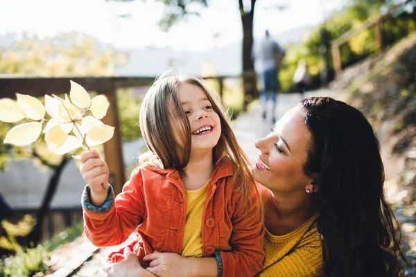 Un retrato de madre joven con una hija pequeña en otoño . —  Fotos de Stock