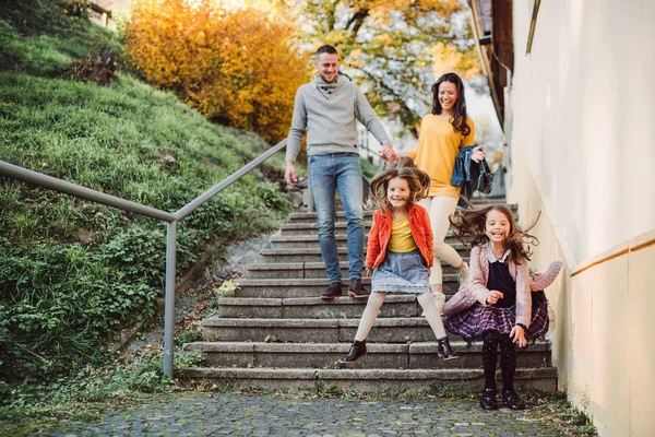 Küçük kızı olan genç bir aile şehirde açık havada merdivenlerden aşağı yürüyor. — Stok fotoğraf