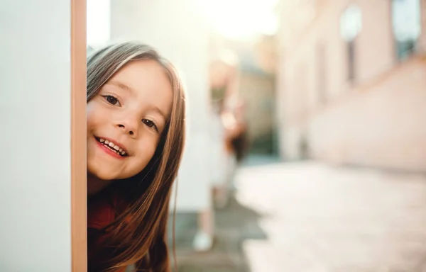 Sonbaharda şehirde eğlenen küçük bir kız, kameraya bakıyor.. — Stok fotoğraf