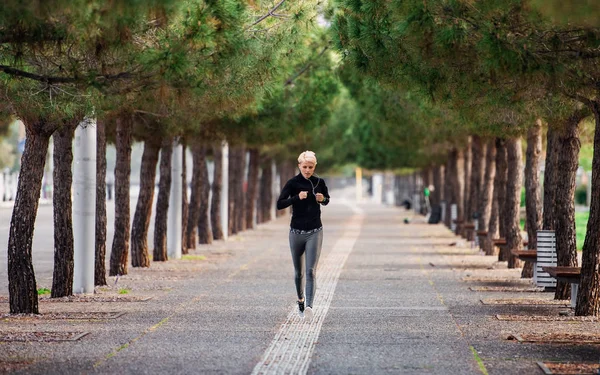 Frontansicht einer jungen Sportlerin, die im Park im Freien läuft. — Stockfoto