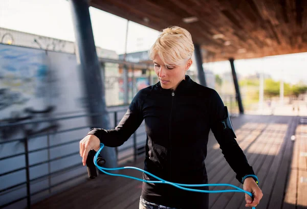 Eine junge Sportlerin, die im Freien Sport treibt und dabei hüpft. — Stockfoto