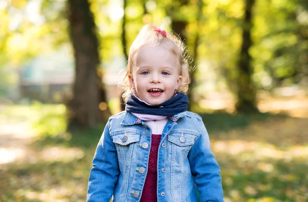 Retrato de vista frontal de uma pequena menina em pé na floresta de outono . — Fotografia de Stock