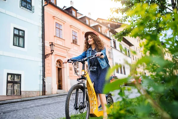 Küçük bir kasabada elektrikli scooter ile güzel genç kadın turist gezgin. — Stok fotoğraf