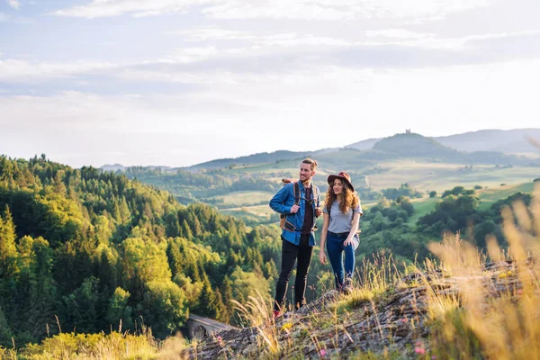 Jong toeristisch paar reizigers met rugzakken wandelen in de natuur, rusten. — Stockfoto