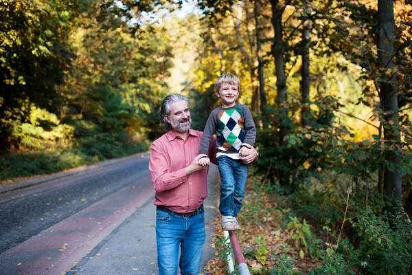 Pai maduro com o pequeno filho em um passeio na natureza, andando sobre trilhos . — Fotografia de Stock