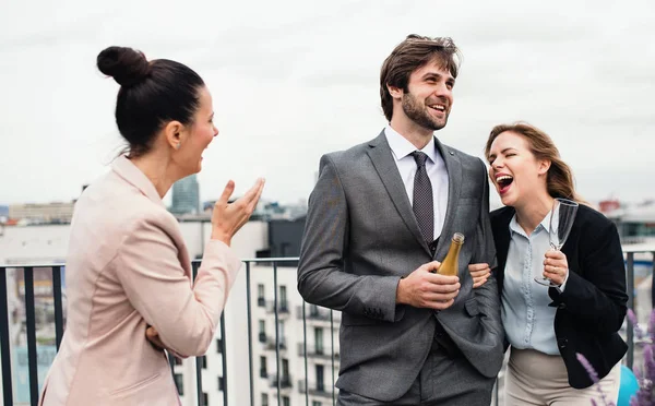 En grupp glada affärsmän som har en fest utomhus på takterrassen i staden. — Stockfoto