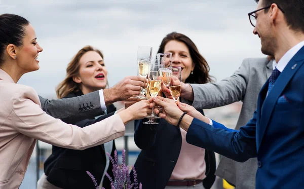 En grupp glada affärsmän som har en fest utomhus på takterrassen i staden. — Stockfoto