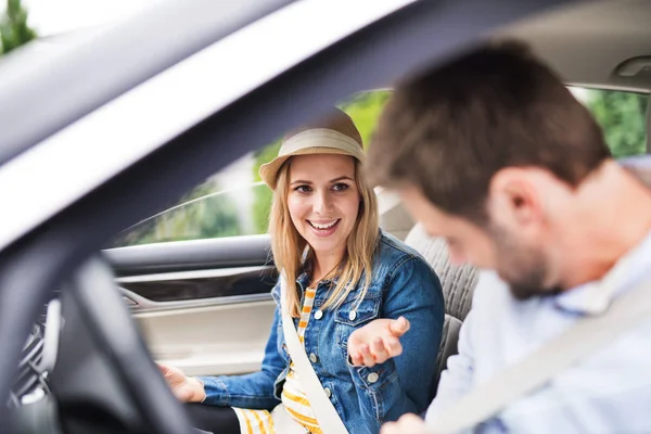 Ευτυχισμένο νεαρό ζευγάρι κάθεται στο αυτοκίνητο, μιλάει. — Φωτογραφία Αρχείου