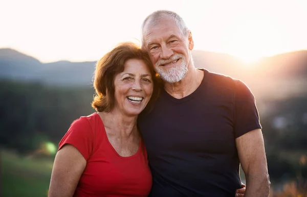 Portrait of senior tourist couple hikers standing in nature, looking at camera. — Stock Photo, Image