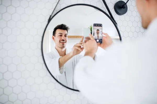 Junger Mann morgens im Badezimmer und macht Selfie. — Stockfoto