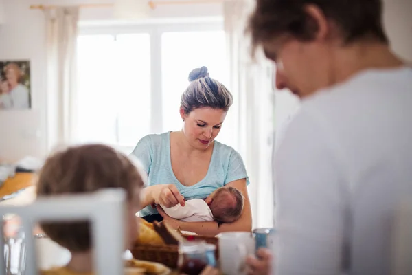 Unga föräldrar med nyfött barn och småbarns son hemma. — Stockfoto