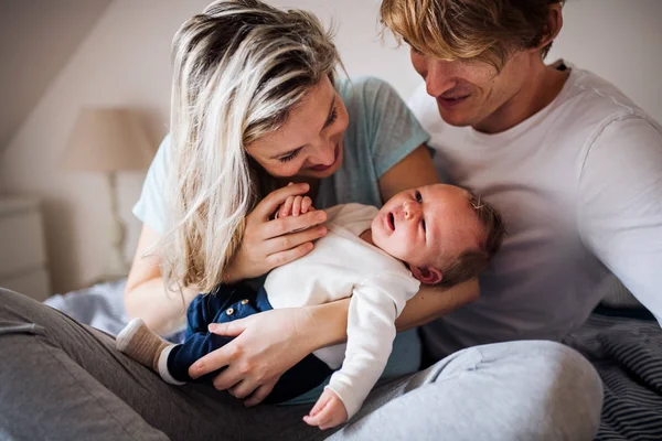 Belos pais jovens com um bebê recém-nascido em casa . — Fotografia de Stock