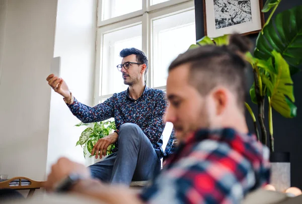 En grupp unga vänner som kopplar av inomhus, hus delnings koncept. — Stockfoto