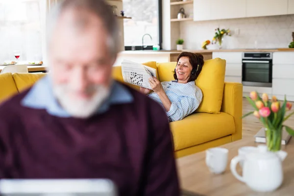 Um casal de idosos dentro de casa, relaxante . — Fotografia de Stock