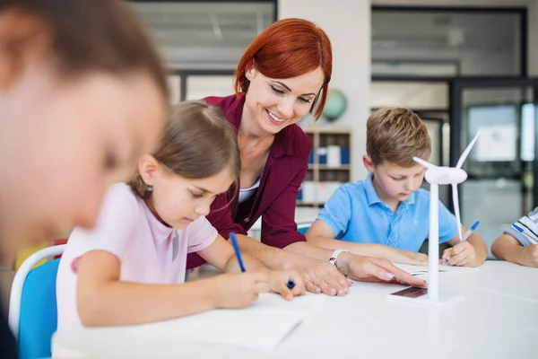 Egy csoport a kis iskolás gyerekek tanár osztályban megismerése környezet. — Stock Fotó