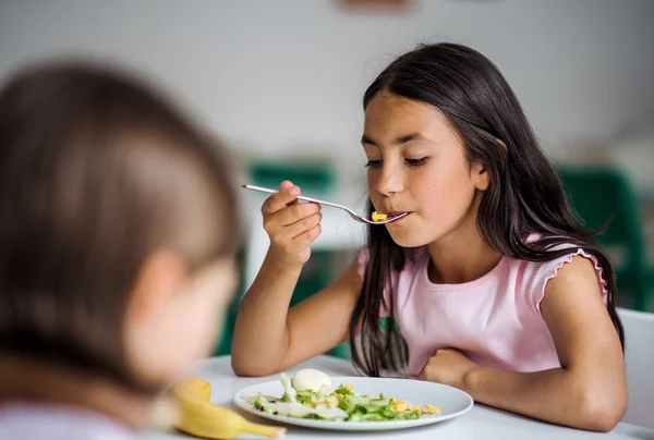 Small school girlas in canteen, eating lunch. — Stock Photo, Image
