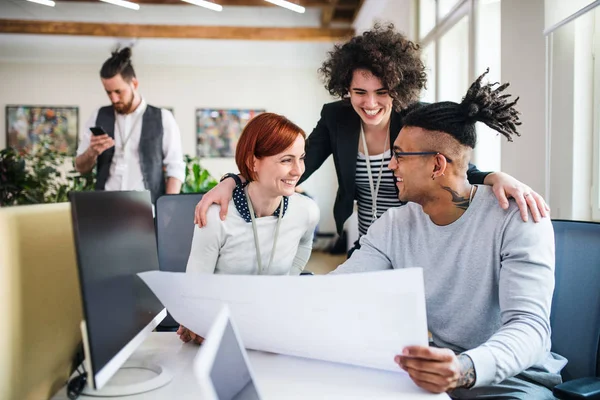 Gruppe junger Unternehmer mit Laptop im Büro, Start-up-Konzept. — Stockfoto