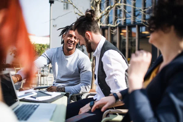 Young businesspeople with laptop in courtyard, start-up concept. — Stock Photo, Image
