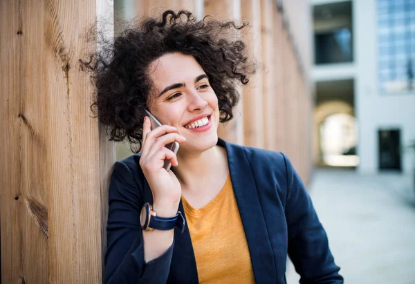 Egy boldog fiatal teendő nő-val smartphone álló kint. — Stock Fotó