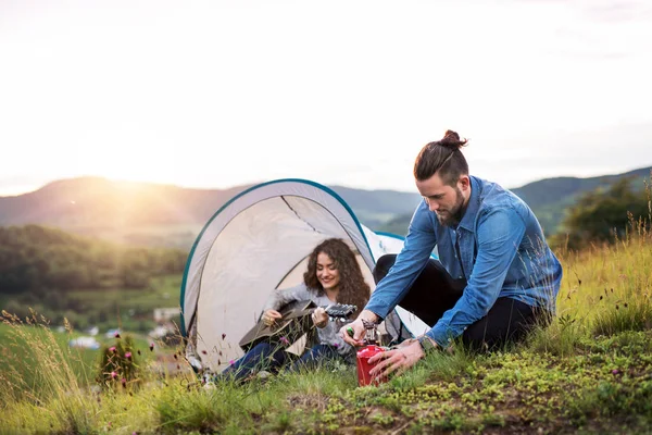 Jeune touriste couple voyageurs avec tente abri assis dans la nature, au repos . — Photo