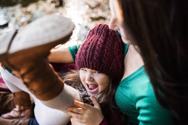 Uma jovem mãe com uma filha criança sentada na floresta no outono natureza . — Fotografia de Stock