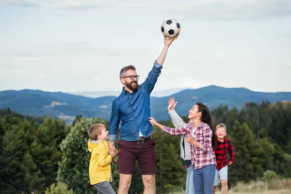 Group of school children with teacher on field trip in nature, playing with a ball. — Stock Photo, Image