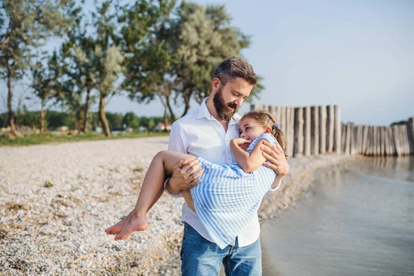 Padre maturo che porta la piccola figlia in vacanza al lago, passeggiando . — Foto Stock