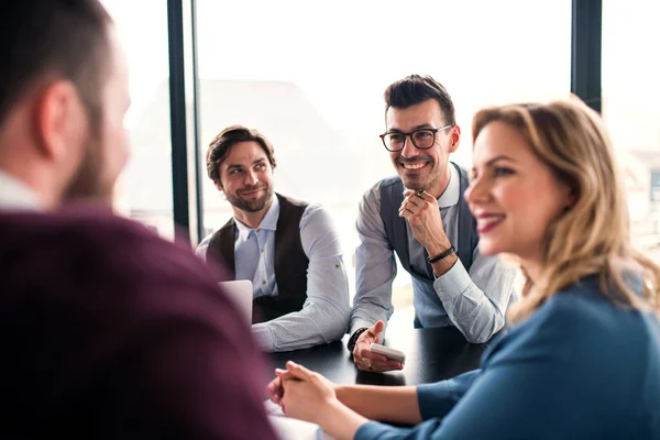 Un groupe de jeunes entrepreneurs assis dans un bureau, ayant une réunion . — Photo