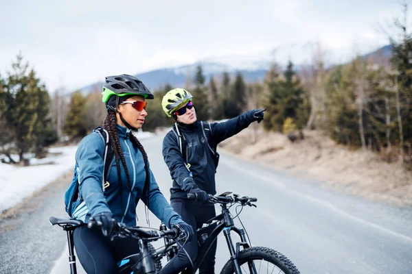 Dos ciclistas de montaña montando en carretera al aire libre en invierno . — Foto de Stock