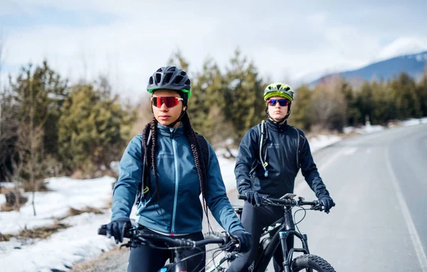 Dva cyklisté na silnici v zimě odpočívají venku. — Stock fotografie