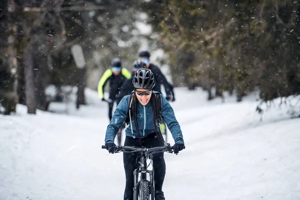 Grupp mountainbikecyklister ridning på väg utomhus på vintern. — Stockfoto