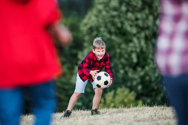 Sekelompok anak-anak sekolah berdiri di lapangan, bermain bola . — Stok Foto