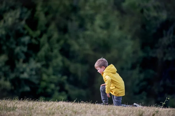 Boční pohled na školní dítě stojící na exkurzi v přírodě, odpočívá. — Stock fotografie