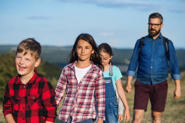 Group of school children with teacher on field trip in nature, walking. — Stock Photo, Image