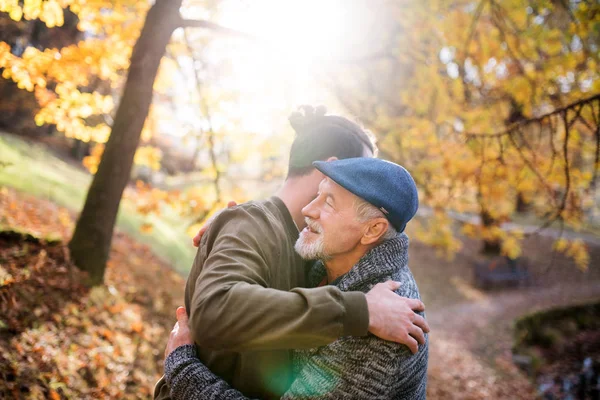 Senior vader en zijn zoon op wandeling in de natuur, knuffelen. — Stockfoto