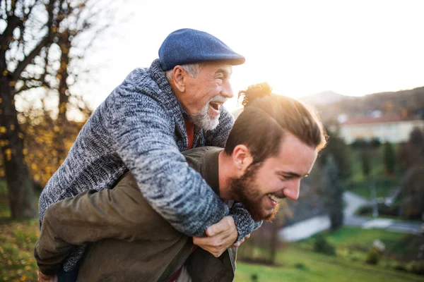 Senior far och hans son gå i naturen, ha kul. — Stockfoto