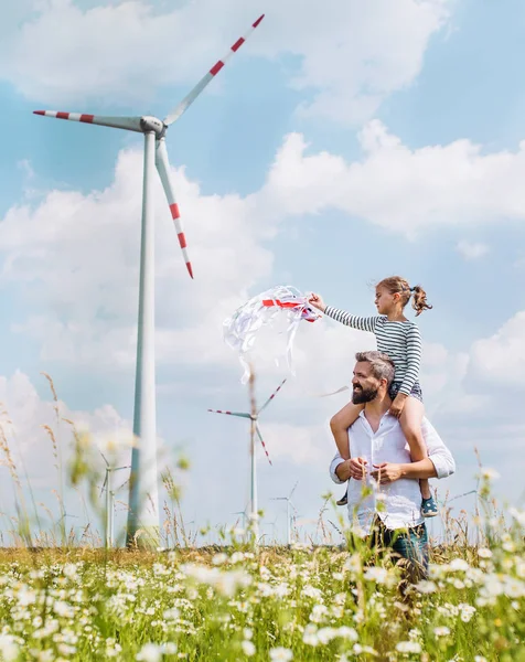 Älterer Vater mit kleiner Tochter läuft auf Feld in Windpark. — Stockfoto