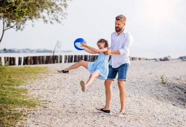 Olgun baba ve göl kenarında oynarken bir tatil de küçük kızı. — Stok fotoğraf