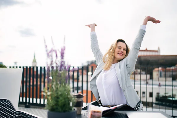 Una giovane donna d'affari in piedi su una terrazza, esprimendo eccitazione . — Foto Stock