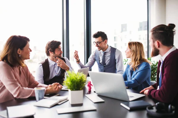A group of young business people sitting in an office, having meeting. — Stock Photo, Image
