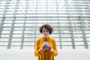 Genç öğrenci veya smartphone bir kütüphane veya office ile iş kadını.