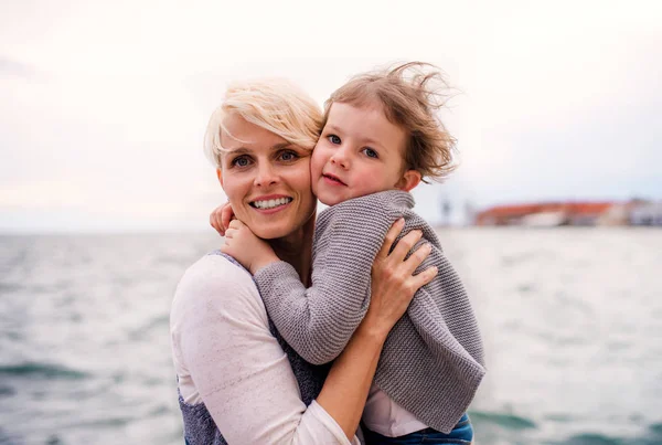 젊은 어머니 와 작은 딸 서 옥외 에 바닷가. — 스톡 사진
