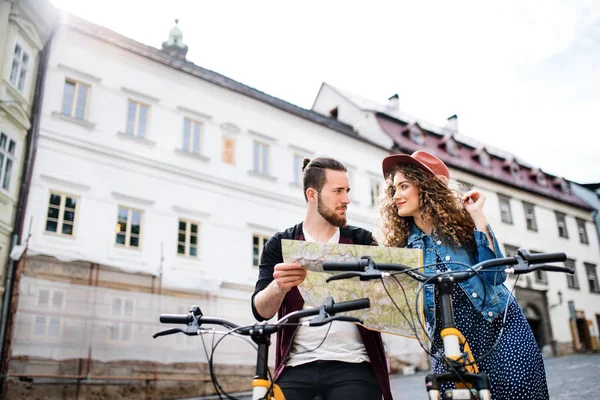 Unga turist par resenärer med karta och skotrar i liten stad. — Stockfoto