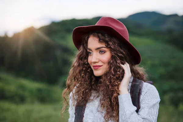 Jovem turista viajante com mochila andando na natureza ao pôr do sol . — Fotografia de Stock