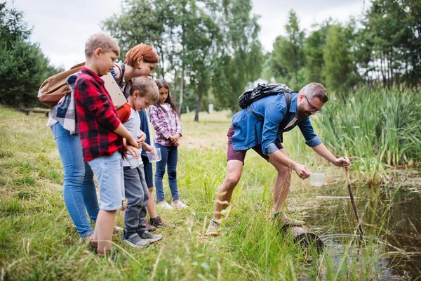 Group of school children with teacher on field trip in nature. — Stock Photo, Image