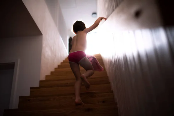 Uma visão traseira de uma criança pequena subindo as escadas . — Fotografia de Stock